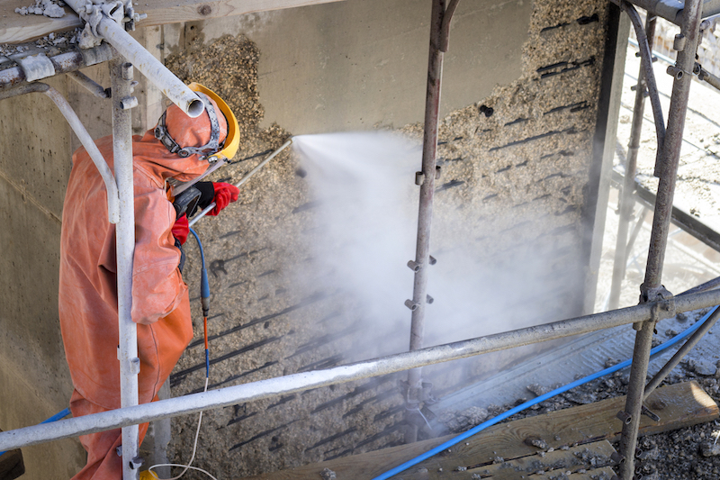 Worker in orange protective suit cleans damage