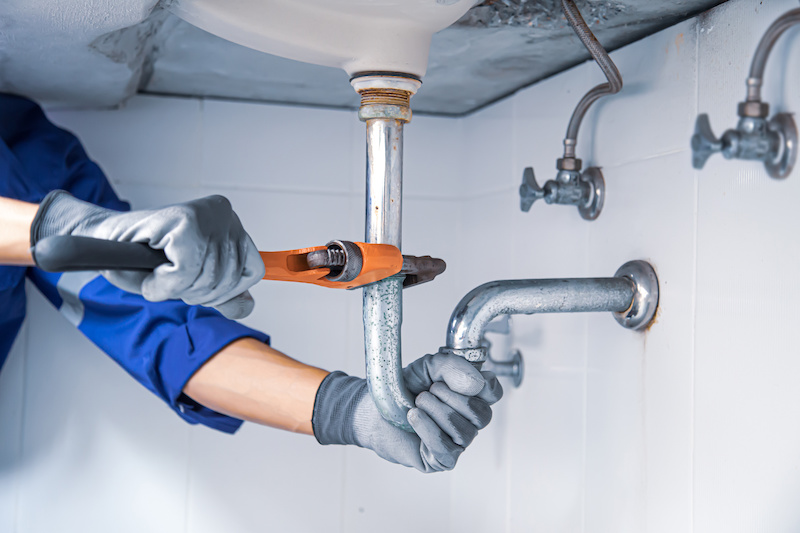 Person fixing a plumbing leak